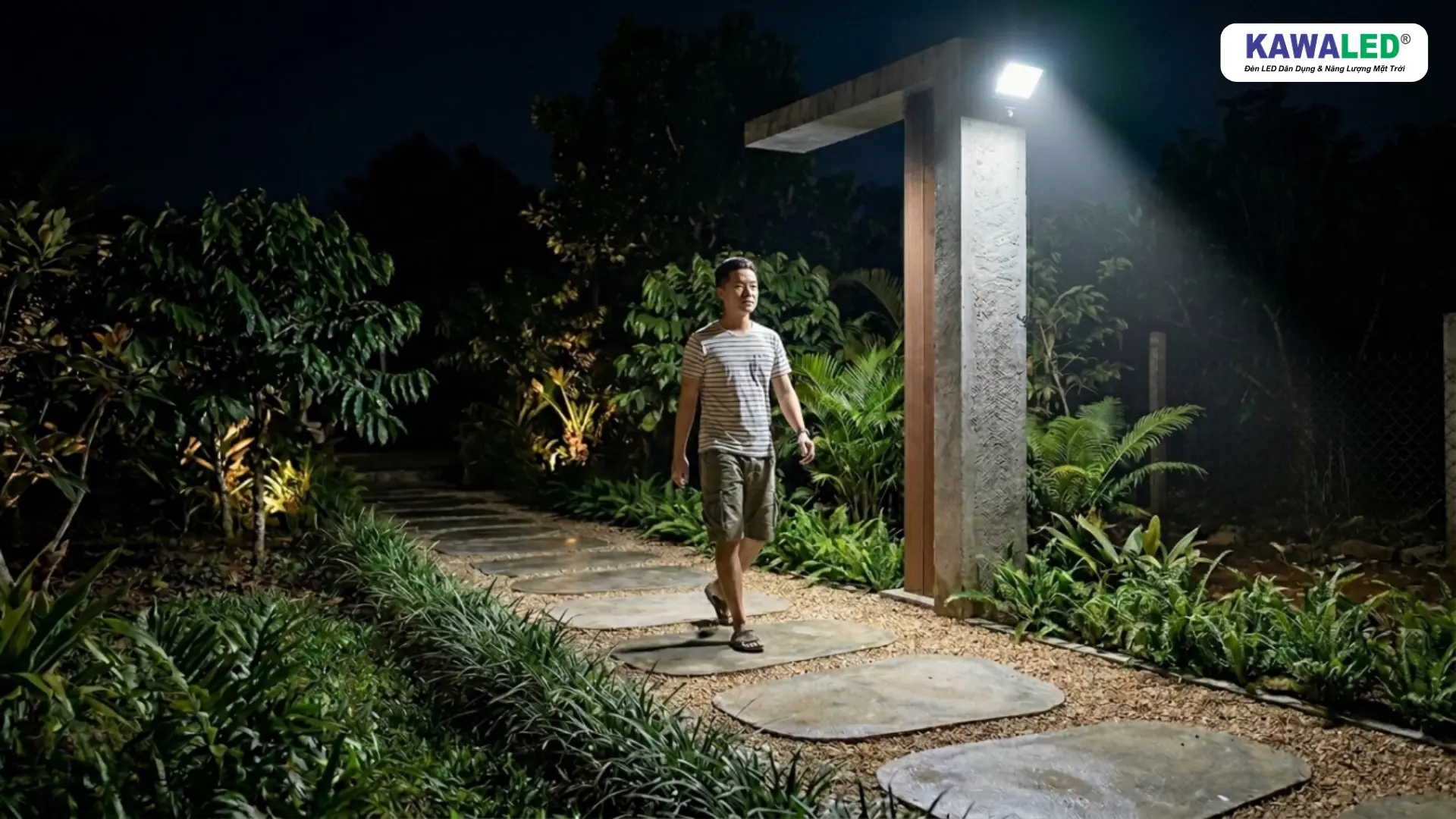Hình ảnh người đi bộ trong sân vườn được đèn cảm ứng hồng ngoại tự động bật sáng giúp di chuyển an toàn hơn vào buổi tối.