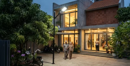 Cặp vợ chồng lớn tuổi đi trong sân được đèn cảm ứng ánh sáng chiếu sáng đều