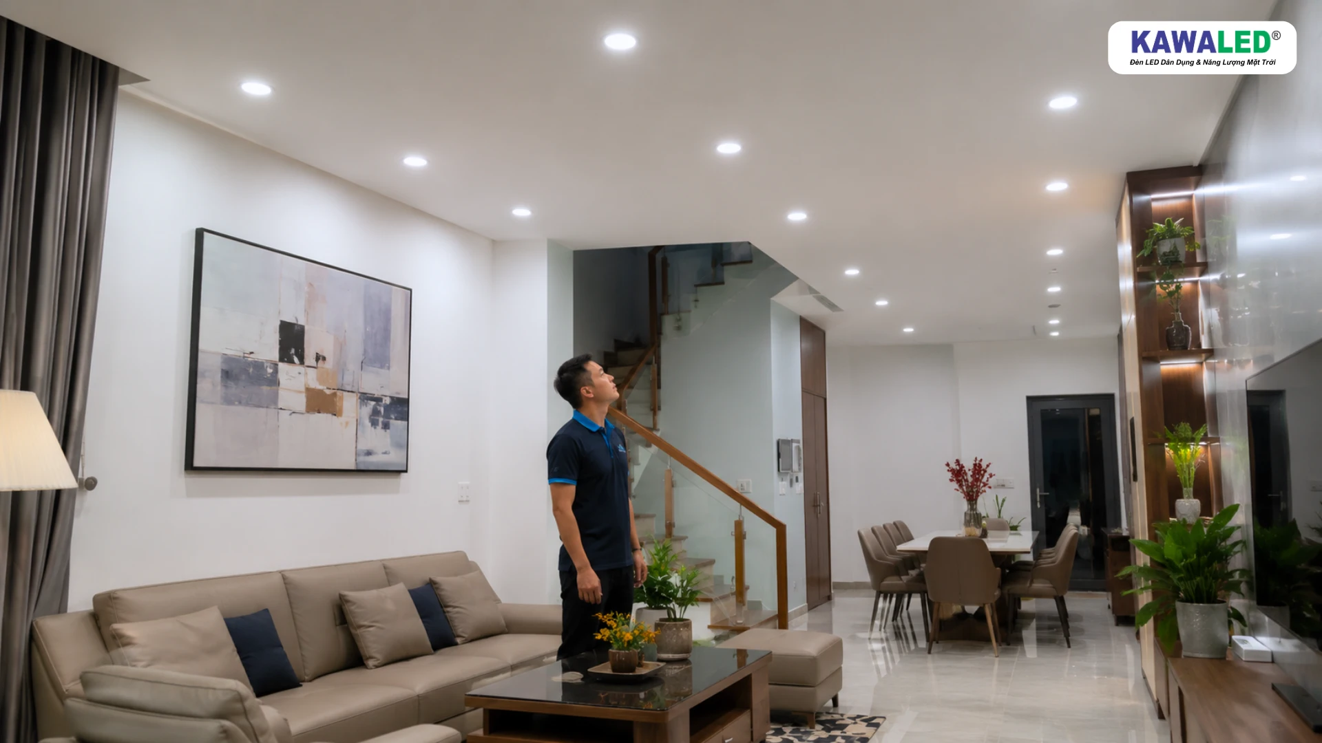Kỹ thuật viên kiểm tra độ sáng và khoảng cách bố trí đèn LED âm trần trên trần thạch cao phòng khách